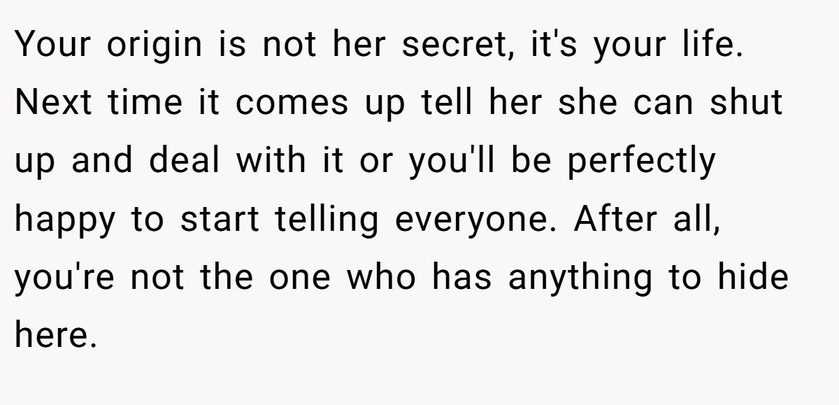 Your origin is not her secret, it's your life. Next time it comes up tell her she can shut up and deal with it or you'll be perfectly happy to start telling everyone. After all, you're not the one who has anything to hide here.