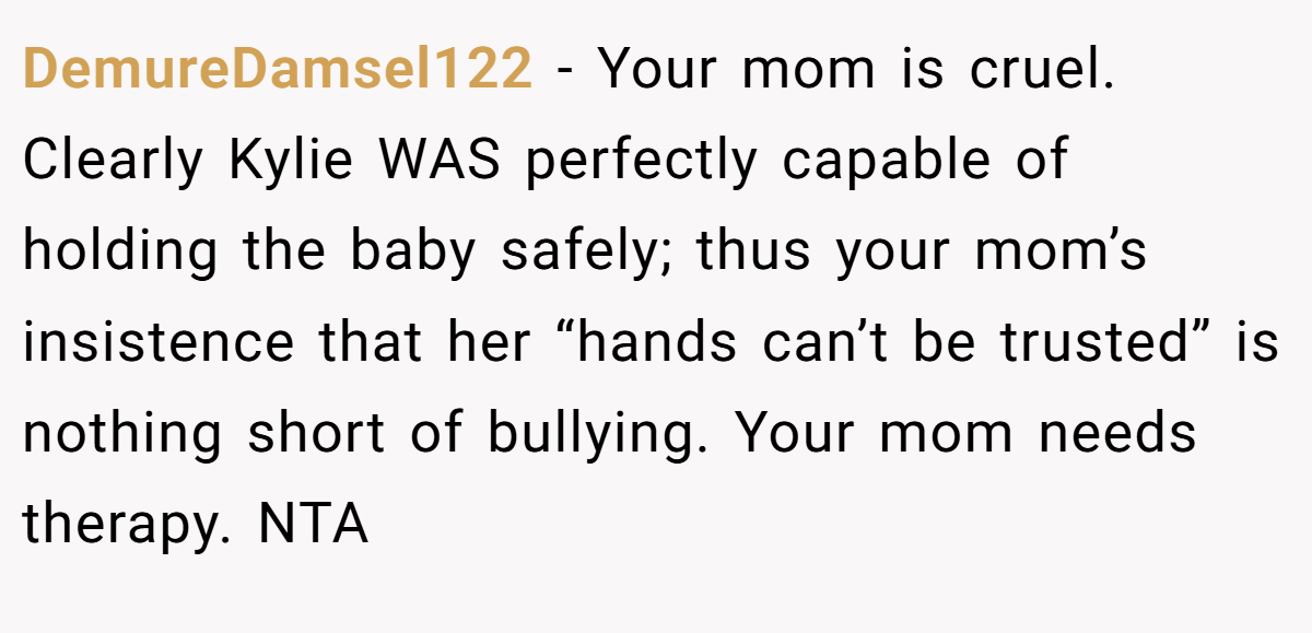 DemureDamsel122 − Your mom is cruel. Clearly Kylie WAS perfectly capable of holding the baby safely; thus your mom’s insistence that her “hands can’t be trusted” is nothing short of bullying. Your mom needs therapy. NTA