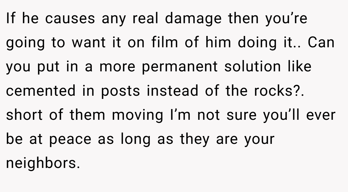 If he causes any real damage then you’re going to want it on film of him doing it.. Can you put in a more permanent solution like cemented in posts instead of the rocks?. short of them moving I’m not sure you’ll ever be at peace as long as they are your neighbors.