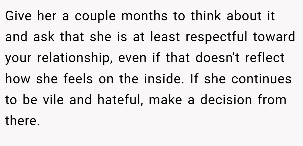 Give her a couple months to think about it and ask that she is at least respectful toward your relationship, even if that doesn't reflect how she feels on the inside. If she continues to be vile and hateful, make a decision from there.
