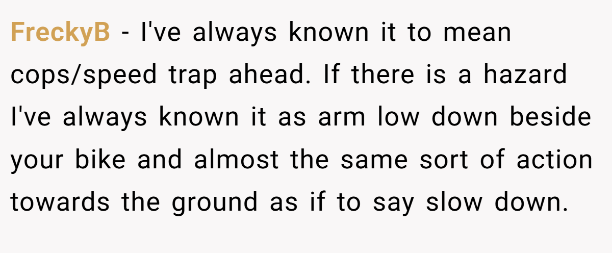FreckyB − I've always known it to mean cops/speed trap ahead. If there is a hazard I've always known it as arm low down beside your bike and almost the same sort of action towards the ground as if to say slow down.