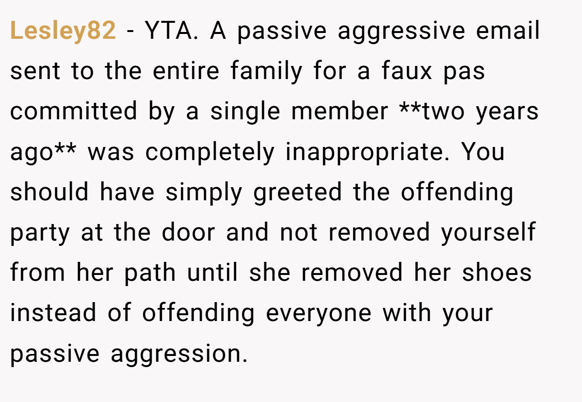 Lesley82 − YTA. A passive aggressive email sent to the entire family for a faux pas committed by a single member **two years ago** was completely inappropriate. You should have simply greeted the offending party at the door and not removed yourself from her path until she removed her shoes instead of offending everyone with your passive aggression.