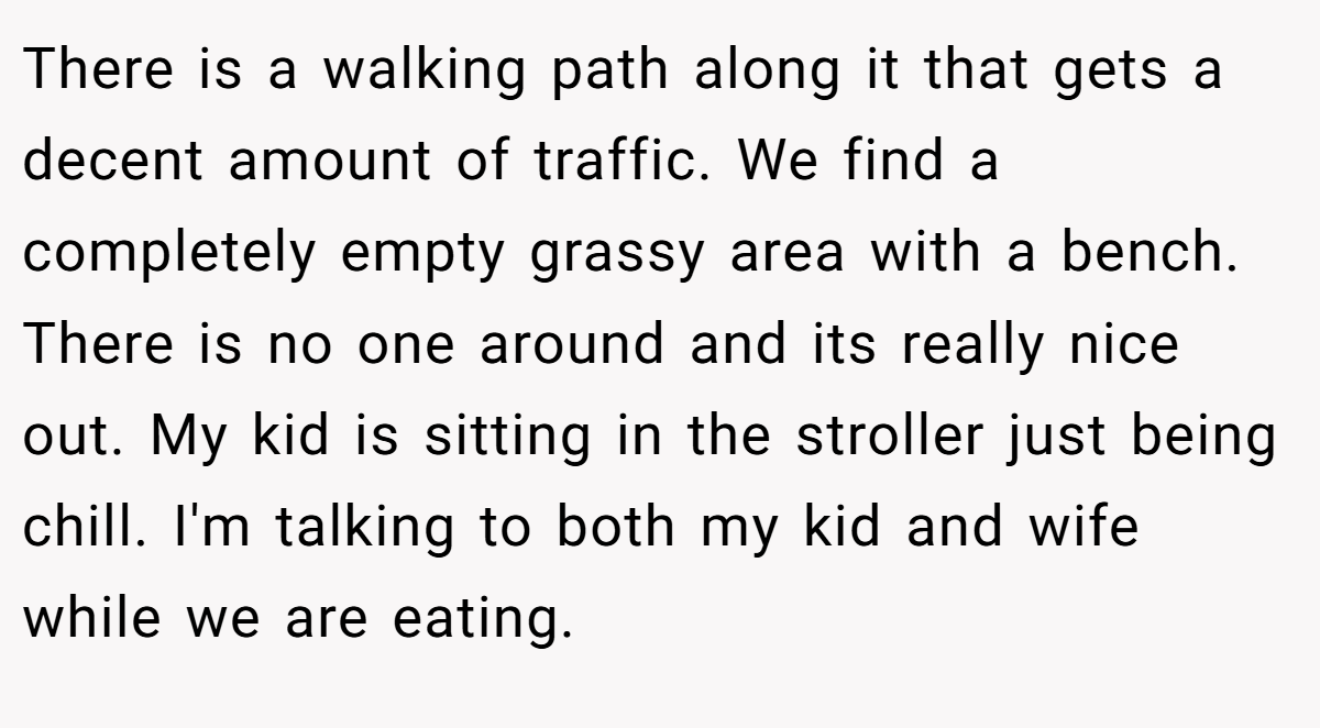 There is a walking path along it that gets a decent amount of traffic. We find a completely empty grassy area with a bench. There is no one around and its really nice out. My kid is sitting in the stroller just being chill. I'm talking to both my kid and wife while we are eating.
