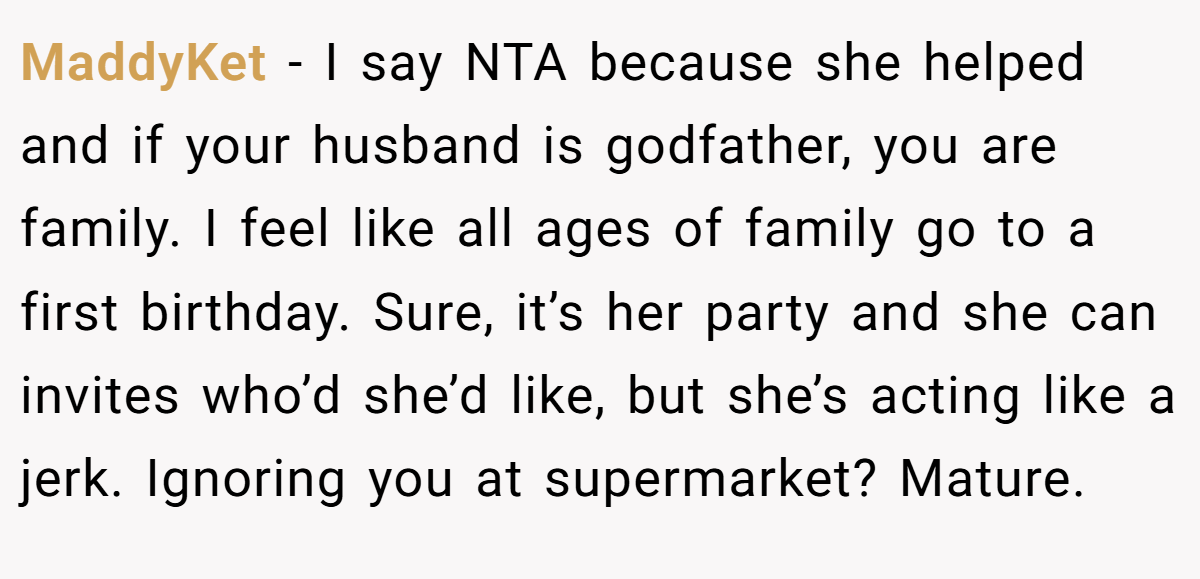 MaddyKet − I say NTA because she helped and if your husband is godfather, you are family. I feel like all ages of family go to a first birthday. Sure, it’s her party and she can invites who’d she’d like, but she’s acting like a jerk. Ignoring you at supermarket? Mature.