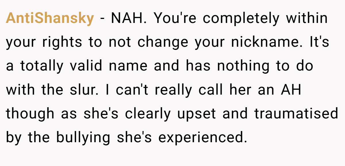 AntiShansky − NAH. You're completely within your rights to not change your nickname. It's a totally valid name and has nothing to do with the slur. I can't really call her an AH though as she's clearly upset and traumatised by the bullying she's experienced.