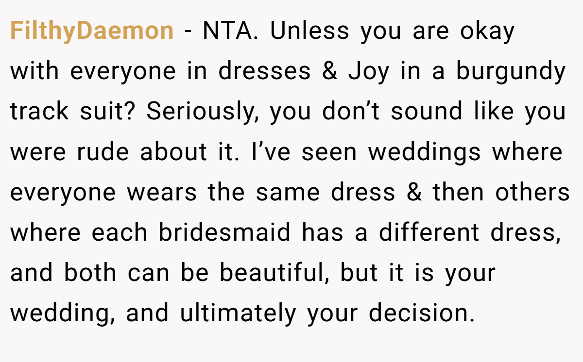 FilthyDaemon − NTA. Unless you are okay with everyone in dresses & Joy in a burgundy track suit? Seriously, you don’t sound like you were rude about it. I’ve seen weddings where everyone wears the same dress & then others where each bridesmaid has a different dress, and both can be beautiful, but it is your wedding, and ultimately your decision.