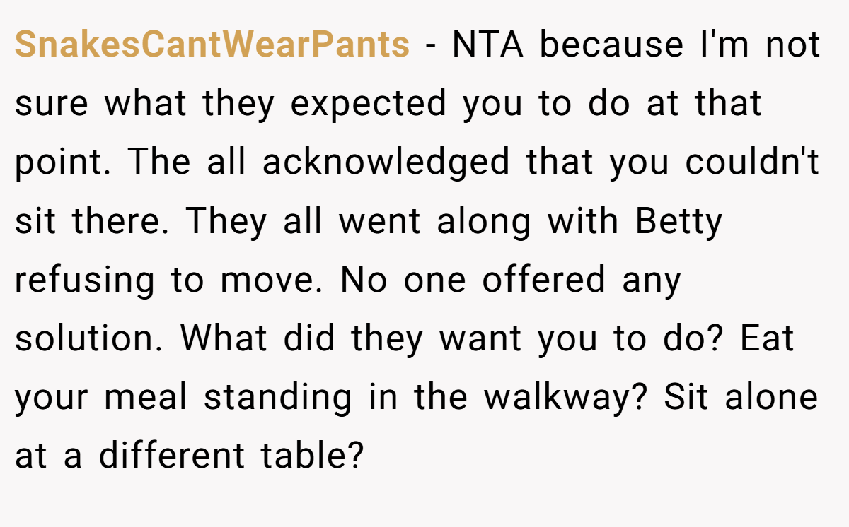 SnakesCantWearPants − NTA because I'm not sure what they expected you to do at that point. The all acknowledged that you couldn't sit there. They all went along with Betty refusing to move. No one offered any solution. What did they want you to do? Eat your meal standing in the walkway? Sit alone at a different table?