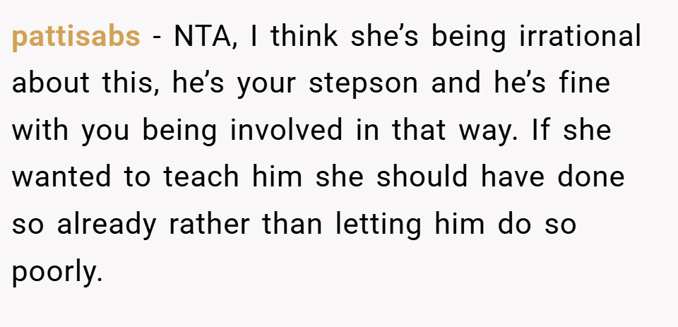 pattisabs − NTA, I think she’s being irrational about this, he’s your stepson and he’s fine with you being involved in that way. If she wanted to teach him she should have done so already rather than letting him do so poorly.