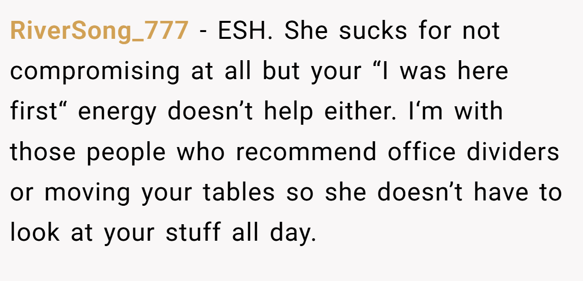 RiverSong_777 − ESH. She sucks for not compromising at all but your “I was here first“ energy doesn’t help either. I‘m with those people who recommend office dividers or moving your tables so she doesn’t have to look at your stuff all day.