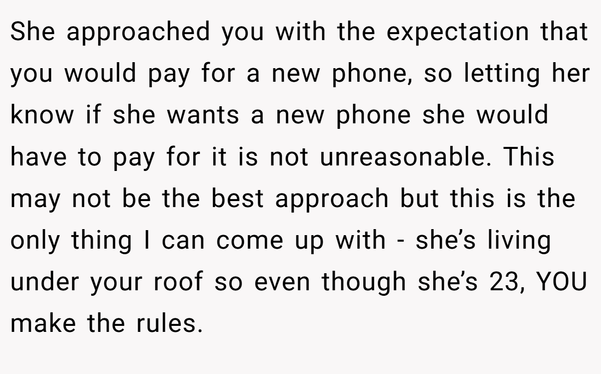 She approached you with the expectation that you would pay for a new phone, so letting her know if she wants a new phone she would have to pay for it is not unreasonable. This may not be the best approach but this is the only thing I can come up with - she’s living under your roof so even though she’s 23, YOU make the rules.