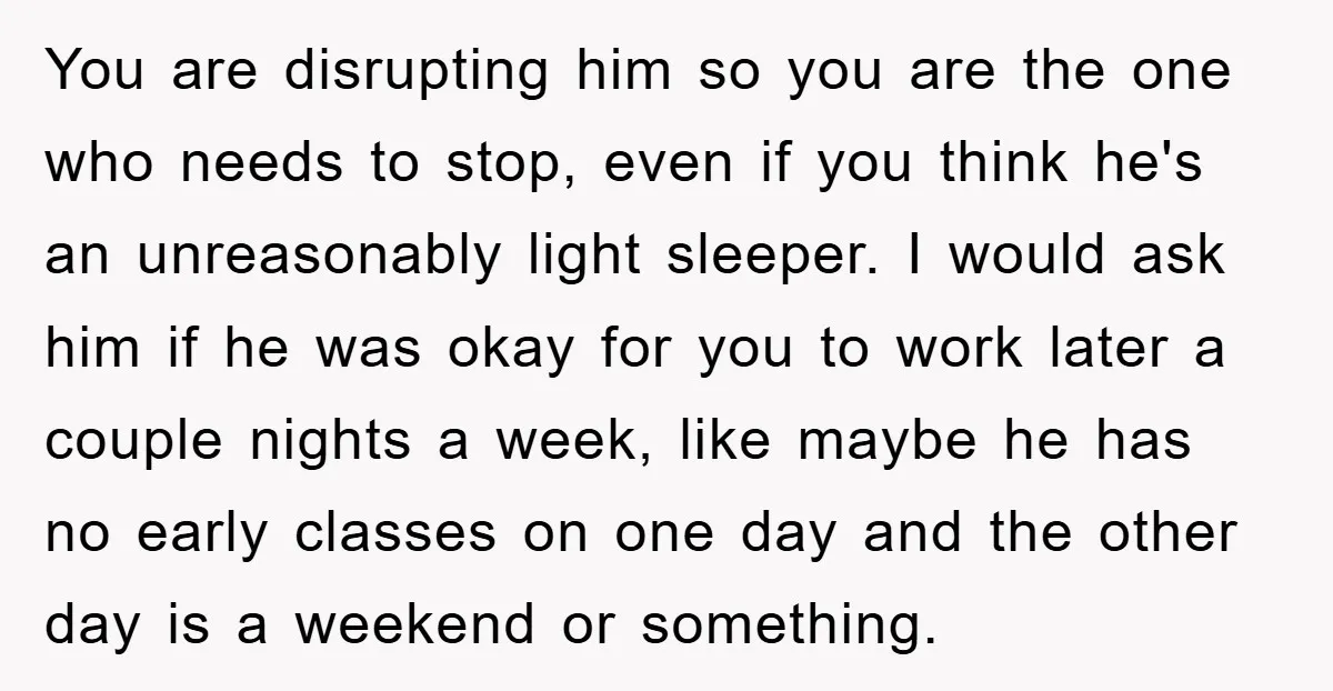 You are disrupting him so you are the one who needs to stop, even if you think he's an unreasonably light sleeper. I would ask him if he was okay...