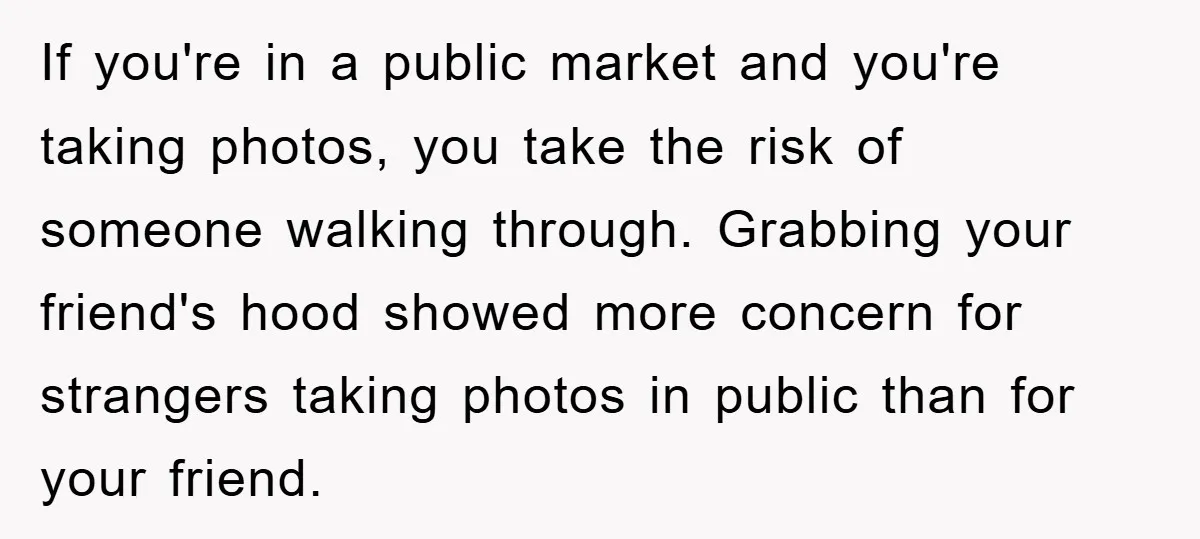If you're in a public market and you're taking photos, you take the risk of someone walking through. Grabbing your friend's hood showed more concern for strangers taking photos in...