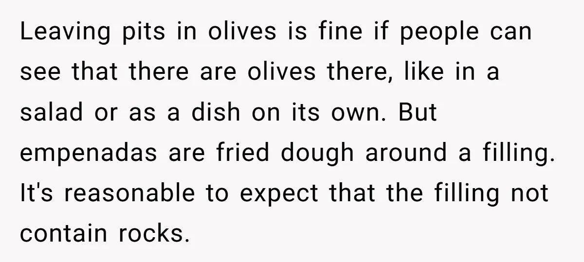 Leaving pits in olives is fine if people can see that there are olives there, like in a salad or as a dish on its own. But empenadas are fried...