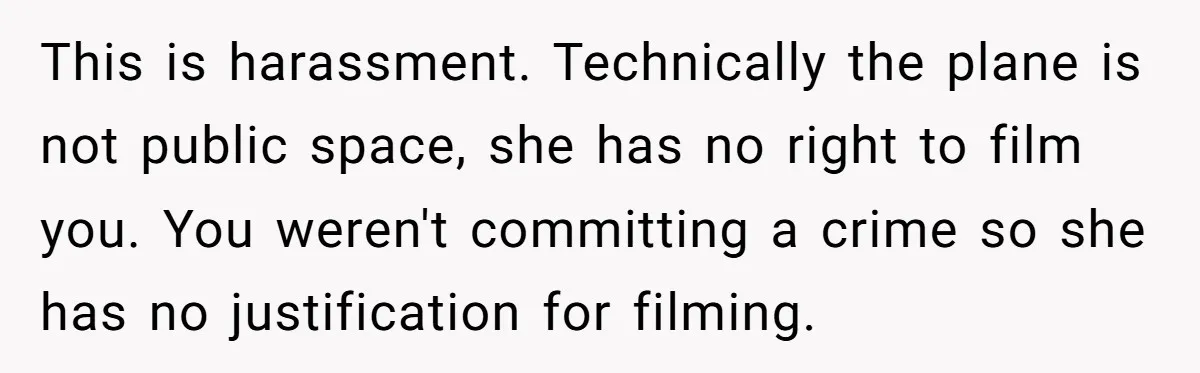 This is harassment. Technically the plane is not public space, she has no right to film you. You weren't committing a crime so she has no justification for filming.