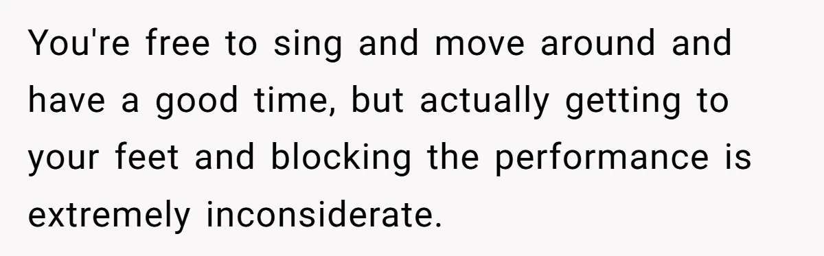 You're free to sing and move around and have a good time, but actually getting to your feet and blocking the performance is extremely inconsiderate.