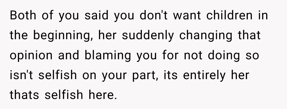 Both of you said you don't want children in the beginning, her suddenly changing that opinion and blaming you for not doing so isn't selfish on your part, its entirely...