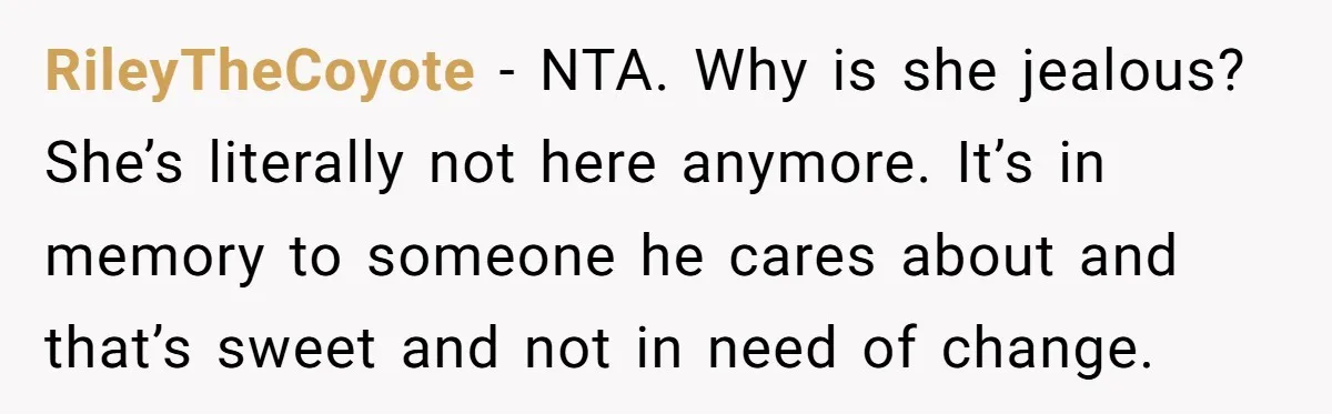 RileyTheCoyote − NTA. Why is she jealous? She’s literally not here anymore. It’s in memory to someone he cares about and that’s sweet and not in need of change.