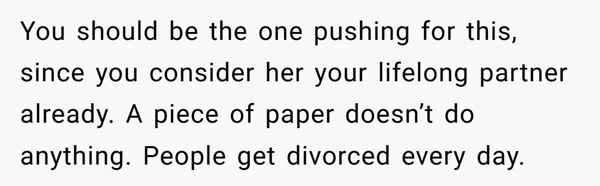 You should be the one pushing for this, since you consider her your lifelong partner already. A piece of paper doesn’t do anything. People get divorced every day.
