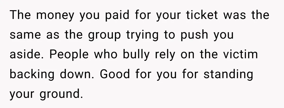 The money you paid for your ticket was the same as the group trying to push you aside. People who bully rely on the victim backing down. Good for you...