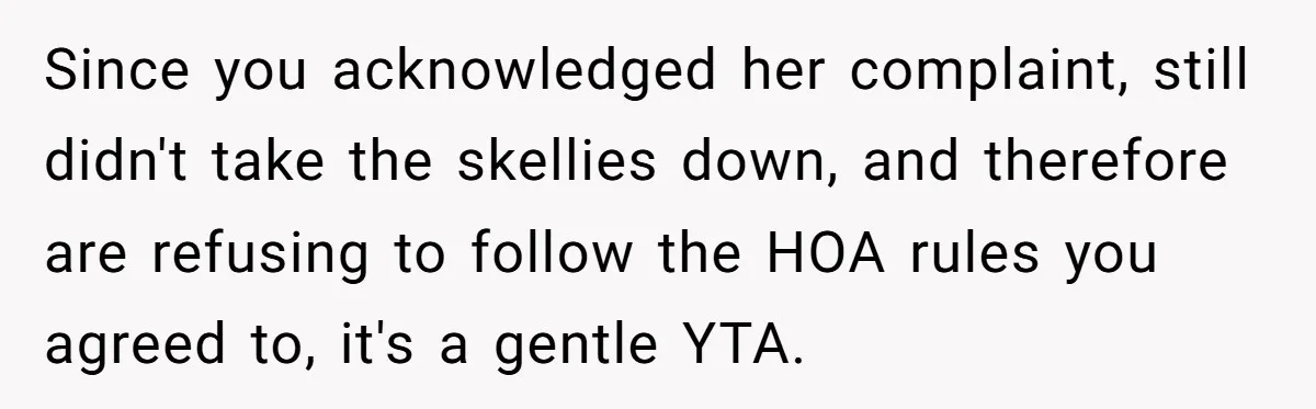 Since you acknowledged her complaint, still didn't take the skellies down, and therefore are refusing to follow the HOA rules you agreed to, it's a gentle YTA.