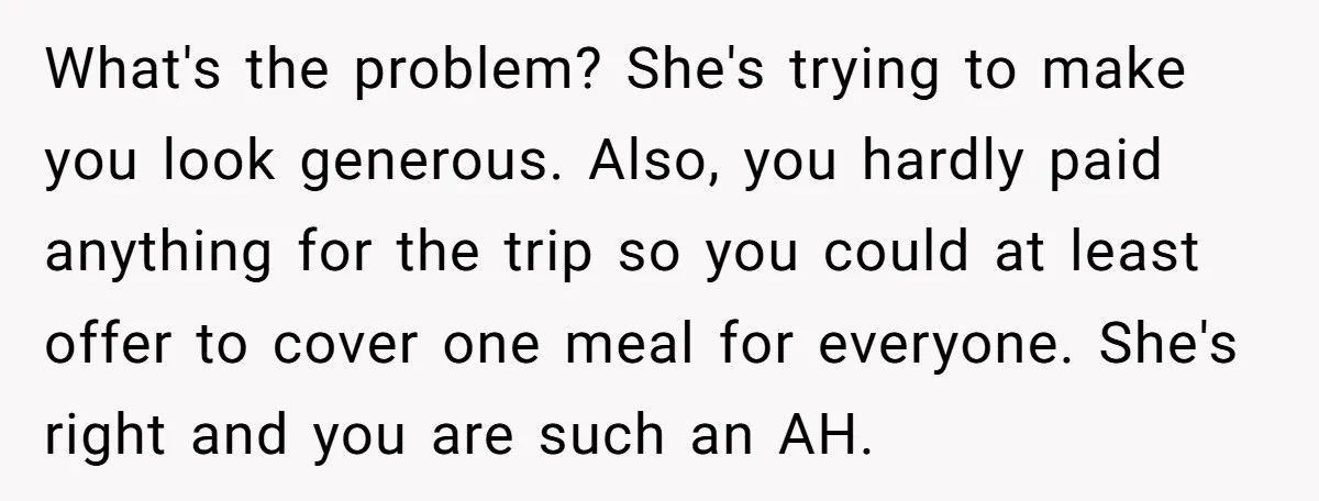 What's the problem? She's trying to make you look generous. Also, you hardly paid anything for the trip so you could at least offer to cover one meal for everyone....