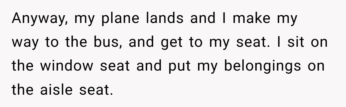 Anyway, my plane lands and I make my way to the bus, and get to my seat. I sit on the window seat and put my belongings on the aisle...