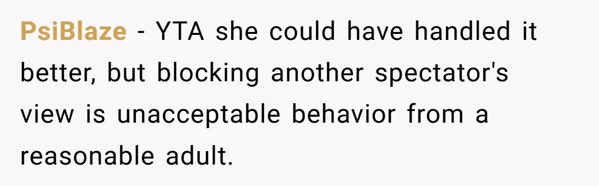 PsiBlaze − YTA she could have handled it better, but blocking another spectator's view is unacceptable behavior from a reasonable adult.