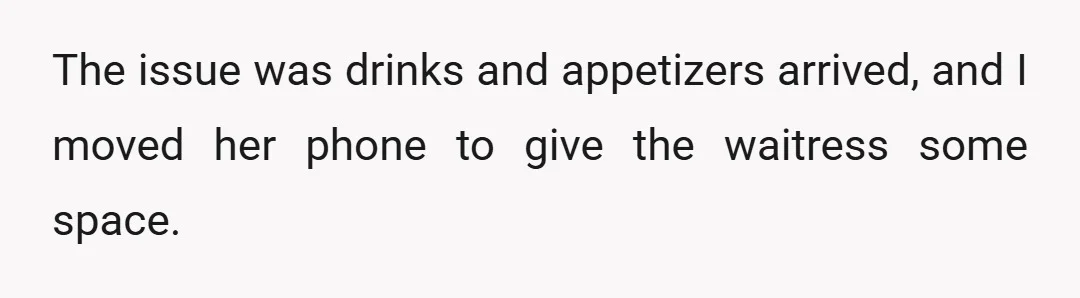 The issue was drinks and appetizers arrived, and I moved her phone to give the waitress some space.